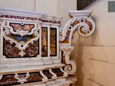 l postergale, cio� la parte superiore del monumento, � diviso in due livelli, entrambi limitati da decori a volute